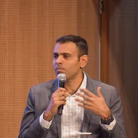 Vikas K Vijayakumar speaking at a technology conference, mid-answer with a microphone in hand